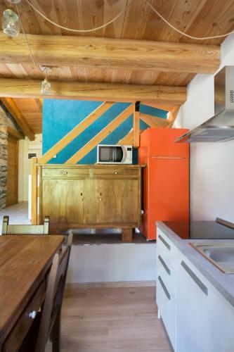 a kitchen with a table and a microwave on a counter at AlfaBaita in Sampeire