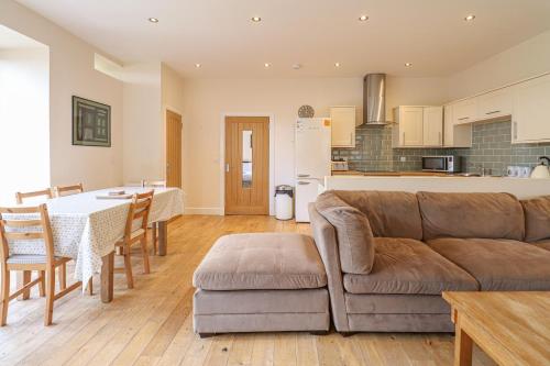 a living room and kitchen with a couch and a table at Fantastic Cottage in Loch Lomond National Park in Alexandria