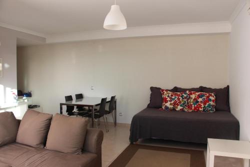 a living room with a couch and a table at Ocean and pool in Olhos de Água