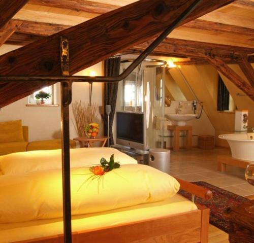 ein Schlafzimmer mit einem Bett und einem TV sowie ein Badezimmer in der Unterkunft Klosterstüble in Rothenburg ob der Tauber