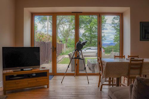 una cámara en un trípode en una sala de estar con TV en Fantastic Cottage in Loch Lomond National Park, en Alexandria