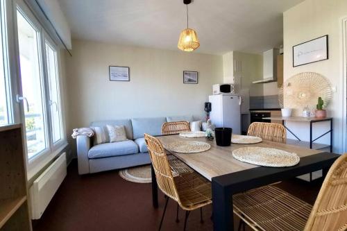 un salon avec une table et un canapé bleu dans l'établissement COC - La Vague - Vue Mer, à Wissant