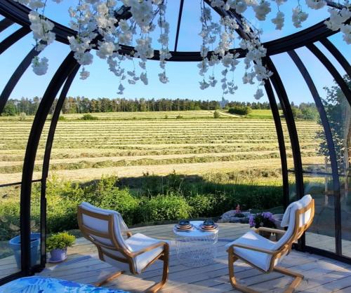 um gazebo com cadeiras e vista para um campo em Au Clair de ma Bulle em Marche-en-Famenne