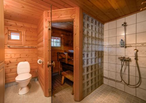 a wooden bathroom with a toilet and a shower at Kuhahuvila, Kalajärvi, Maatilamatkailu Ilomäen mökit in Peräseinäjoki