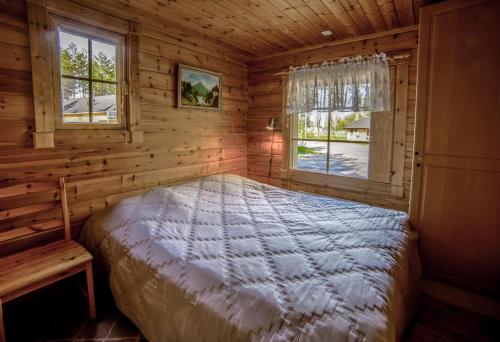 ein Schlafzimmer mit einem Bett in einem Blockhaus in der Unterkunft Kuhahuvila, Kalajärvi, Maatilamatkailu Ilomäen mökit in Peräseinäjoki