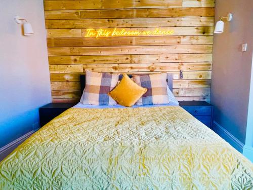 a bedroom with a bed with a wooden headboard at The White Horse in Shipston on Stour