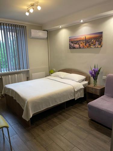 a bedroom with a large bed and a purple chair at 7Days in Hadyach