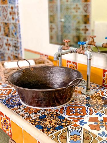 a bathroom sink with a copper bowl on a counter at Hotel Boutique Santo Cuervo in Bernal