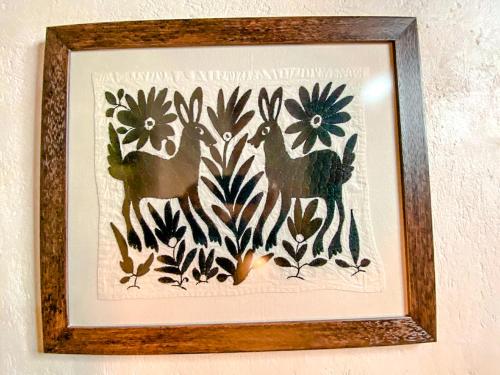 a framed picture of two deer and flowers at Hotel Boutique Santo Cuervo in Bernal