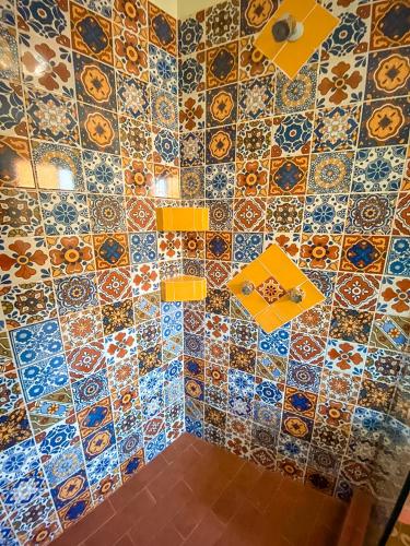 a bathroom with a colorful tiled wall at Hotel Boutique Santo Cuervo in Bernal