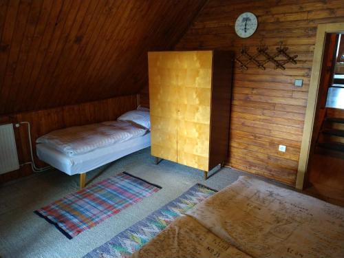 a room with a bed and a clock on the wall at Zelená chalupa Vernár in Vernár