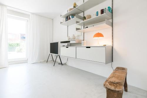 Dieses weiße Zimmer verfügt über eine Bank und einen Schreibtisch. in der Unterkunft Nordlys - Local & Style in Westerland