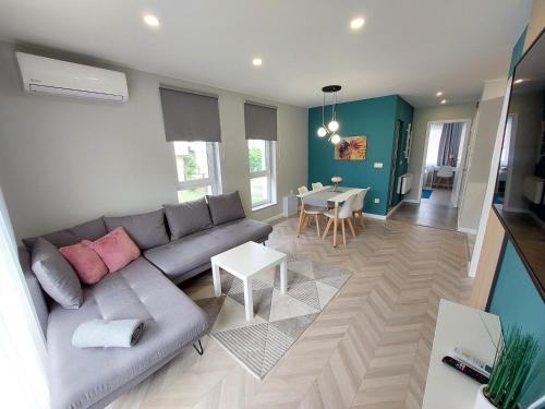 a living room with a couch and a table at "The House" Апартаменти и Термална зона in Velingrad
