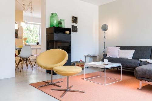a living room with a couch and a chair and a table at Nordlys - Local & Style in Westerland (Sylt)