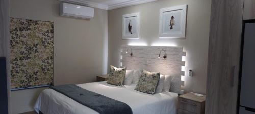 a bedroom with a large white bed with two pillows at Studio 5 The Studios at Churchill in Hillcrest