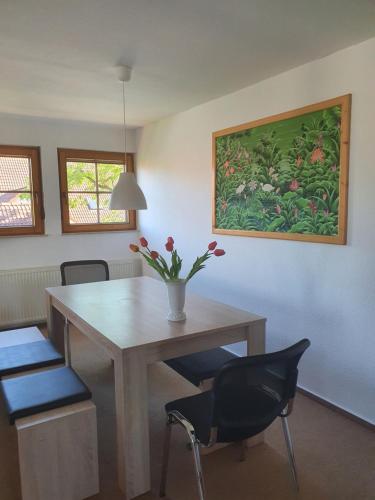 a dining room table with a vase of flowers on it at Ferienwohnung im Schwarzwaldhaus in Behla