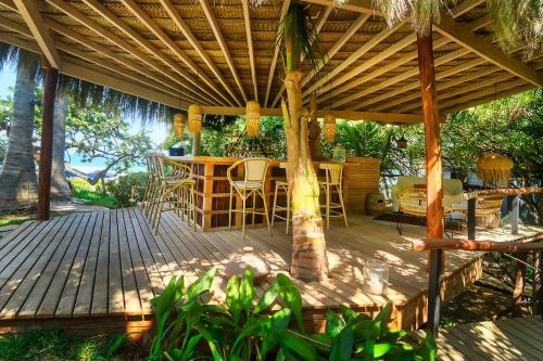 a wooden deck with a table and chairs under a pergola at KiChic in Máncora