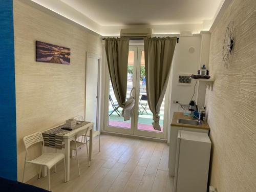 uma sala de estar com uma mesa e uma cozinha com uma janela em ARIA DI SALE ROOM em Margherita di Savoia