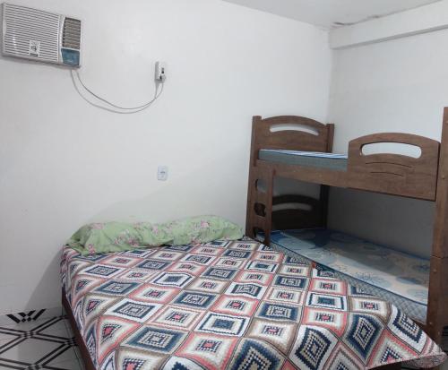 um pequeno quarto com uma cama e uma secretária em Pousada Vicenzi em Luziânia