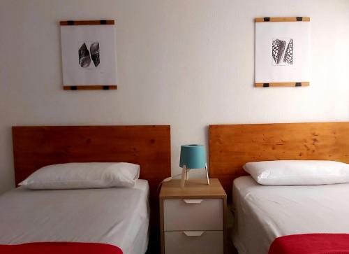 a bedroom with two beds and a table with a lamp at Casa Salamanca in Málaga