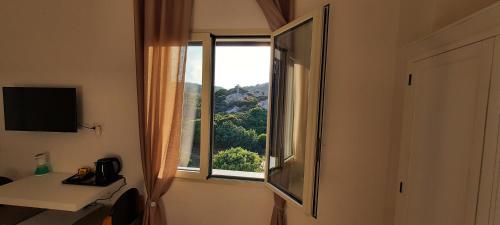 a room with a window with a view at Monte Becco panoramic rooms in Santa Teresa Gallura