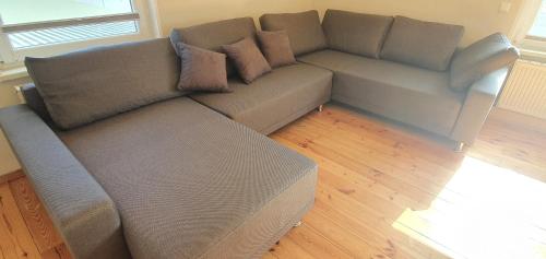 a gray couch in a living room with a wooden floor at FeWo Warnemüde in Warnemünde