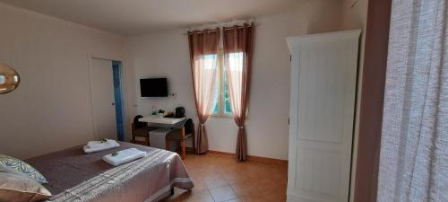 a bedroom with a bed and a desk and a window at Monte Becco panoramic rooms in Santa Teresa Gallura