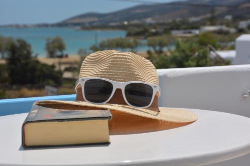 un chapeau de paille et des lunettes de soleil assis au-dessus d'une table dans l'établissement ThalaSEA - village Antiparos, à Antiparos