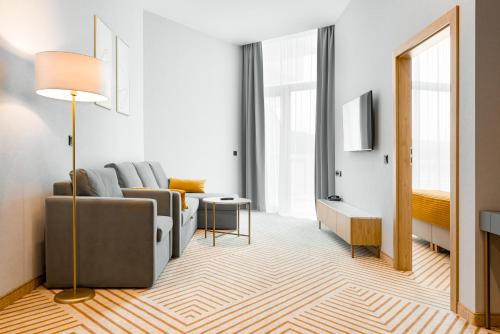 a living room with a couch and a tv at Crystal Mountain Hotel Wisła in Wisła