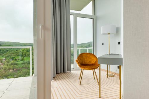 a desk and a chair in a room with a window at Crystal Mountain Hotel Wisła in Wisła