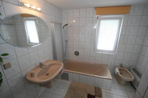 bagno con lavandino, vasca e servizi igienici di Villa Lindwurm a Klagenfurt