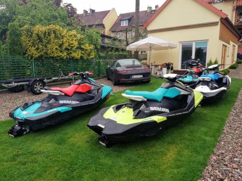 a group of motorcycles parked on the grass at Promenada Apartamenty i Domek Nad Jeziorem in Mikołajki