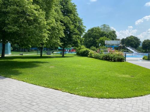 a park with green grass and trees and a playground at Sali Homes - GaesteHaus Lamm Obersulm in Obersulm