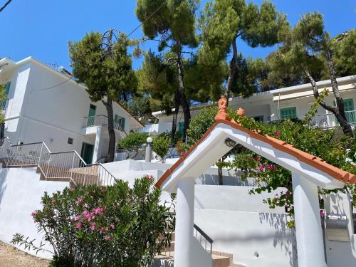 une maison blanche avec des escaliers et des fleurs dans l'établissement Studios Argyris, à Poros