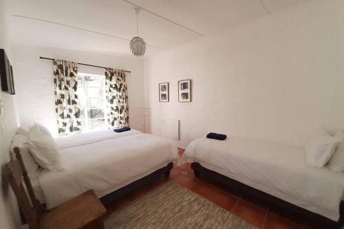 Un pat sau paturi într-o cameră la Snug Cottage