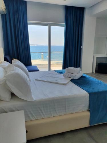 a bedroom with a bed with a view of the ocean at Hotel Aloha in Sarandë