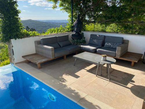 a patio with two couches and a table next to a pool at Casa BelaVista Penela - Charming Guest House - Adults Only in Penela