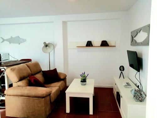a living room with a couch and a table at Apartamentos Empul " Tunidos House " in Barbate