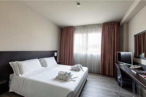 a bedroom with a bed and a desk and a television at Anusca Palace Hotel in Castel San Pietro Terme
