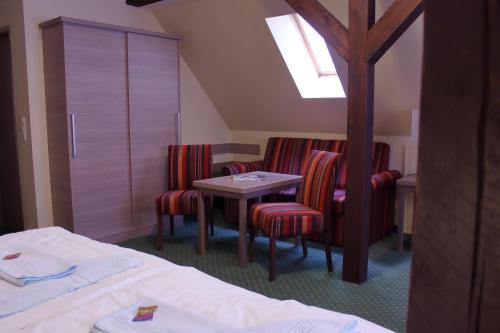 a room with chairs and a table and a bed at Gasthof Zur guten Quelle in Schwerin