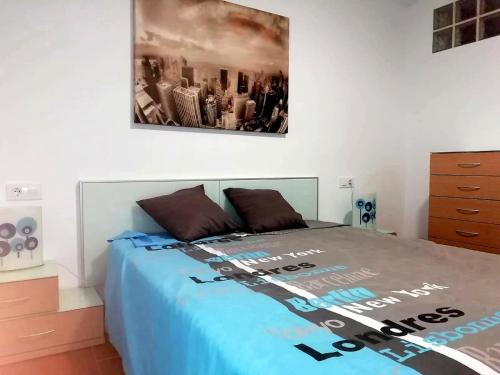 a bedroom with a bed with a poster on the wall at Apartamentos Empul " Tunidos House " in Barbate