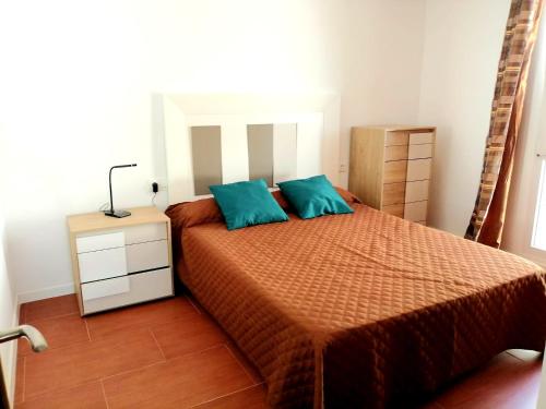 a bedroom with a bed with two blue pillows at Apartamentos Empul " Tunidos House " in Barbate
