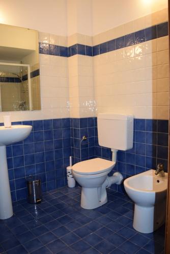 uma casa de banho em azulejos azuis com um WC e um lavatório em Casa Ligure Ristrutturata 80m2 em Diano Marina