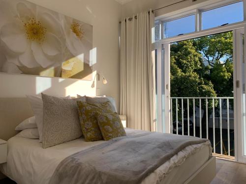 a bedroom with a bed and a large window at Tuishuisie in Stellenbosch