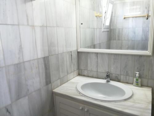 a bathroom with a white sink and a mirror at Petit Andromeda Mykonos I in Mikonos