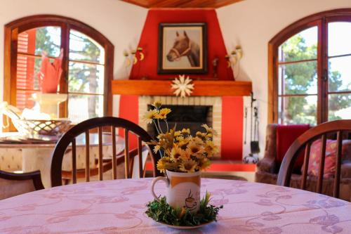 a room with a table with a vase of flowers on it at Pousada da Lua in Campos do Jordão