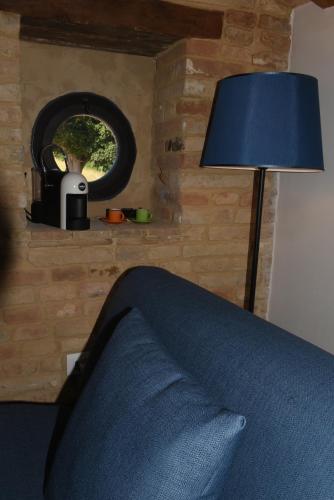 a bedroom with a blue bed with a lamp and a window at Villa Shmitanka in Servigliano