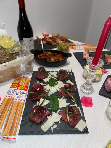 a table with plates of food and a bottle of wine at Elite Apartment SPA in Catania