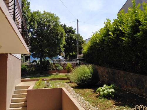 a garden outside a house with a sink at Apartments Sabo in Kraljevica