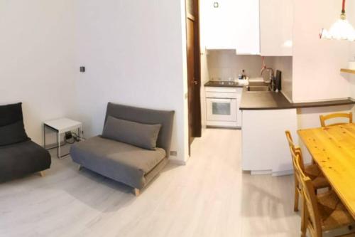 una cucina e un soggiorno con divano e tavolo di Appartamento Residence Castel Carlotta a Levico Terme